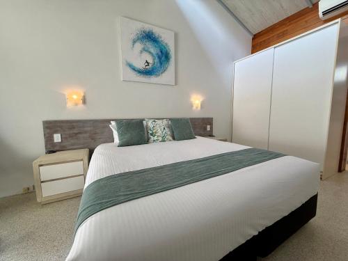 a bedroom with a large white bed in a room at Nautilus Beach Resort by Charlesworth in Coffs Harbour
