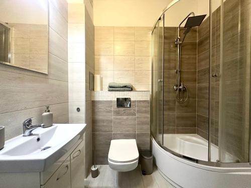 a bathroom with a shower and a toilet and a sink at Kotlarska 39 Apartment - Self Check-In 20h in Wrocław