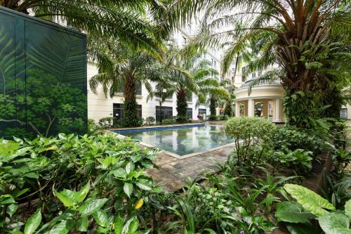 a swimming pool in the middle of a building with palm trees at Hygg Hotel Phu Quoc in Phu Quoc