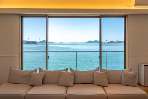 a white couch in a room with large windows at Nagisato Villa Clover in Takamatsu