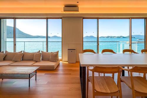 a living room with a couch and a table and chairs at Nagisato Villa Clover in Takamatsu