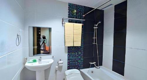 une salle de bain avec un lavabo, des toilettes et une baignoire dans l'établissement The Aroma's of Bali Hotel & Residence, à Legian