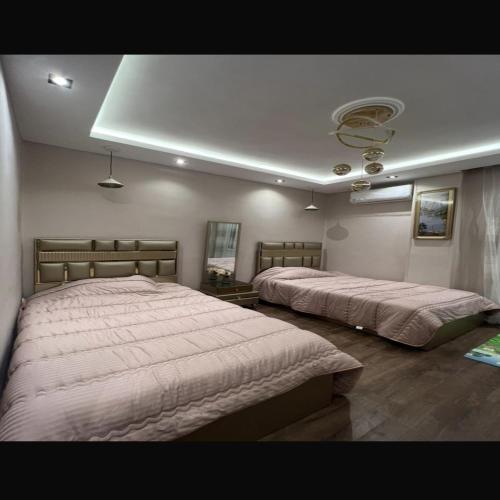 a bedroom with two beds and a ceiling at شقة عائليةvip in Cairo
