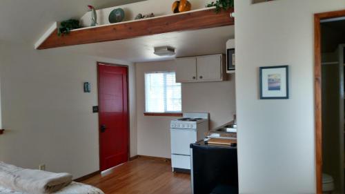 a kitchen with a red door and a white stove at Jones Cabin in Friday Harbor