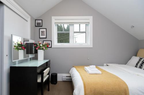 ein Schlafzimmer mit Bett, Schreibtisch und Fenster in der Unterkunft Brand New Stylish 2 bedrooms Suite in Shaughnessy in Vancouver