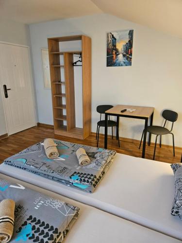 Ce lit se trouve dans un dortoir doté d'une table et de chaises. dans l'établissement Apartments Peka, à Dušanovac (historical)