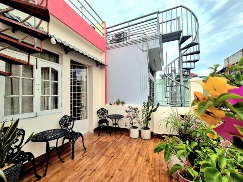Un balcón con sillas y mesas en un edificio. en F F HOUSE Homestay, en Ho Chi Minh