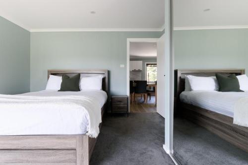 a bedroom with two beds and a mirror at Melrose Retreat with Court Access in Melrose