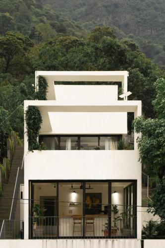 eine weiße Fassade eines Hauses auf einem Hügel in der Unterkunft Aviva Hotel in Tzununá