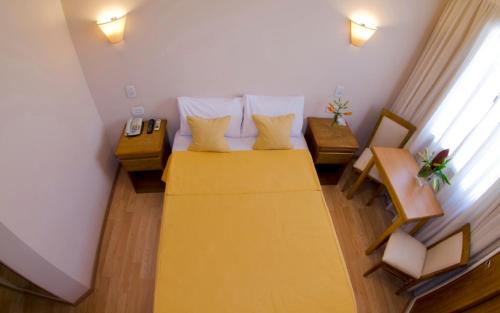 a small room with a bed and two tables at Hotel Rey in Buenos Aires