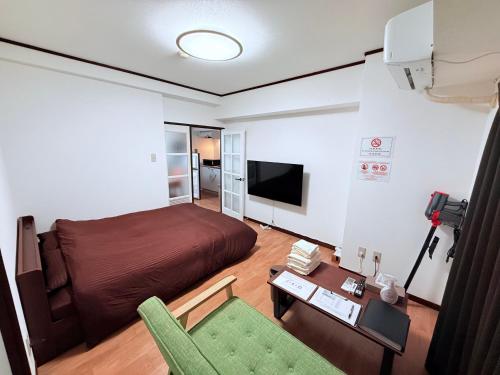 a bedroom with a bed and a couch and a table at Stay Plus Sophia in Utsunomiya