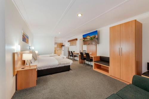 a hotel room with a bed and a desk at Bundaberg International in Bundaberg