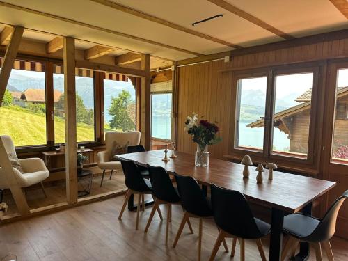 Un comedor con una gran mesa y sillas de madera. en Chalet Zytrösli, en Sigriswil