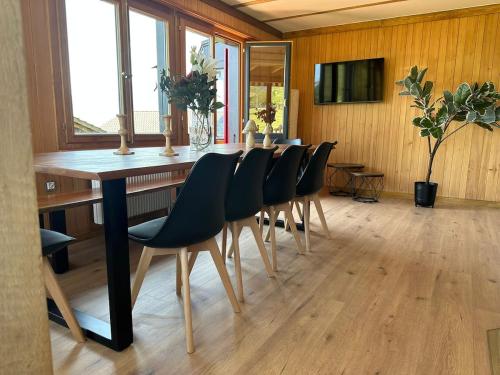 Un comedor con una mesa larga y sillas. en Chalet Zytrösli, en Sigriswil