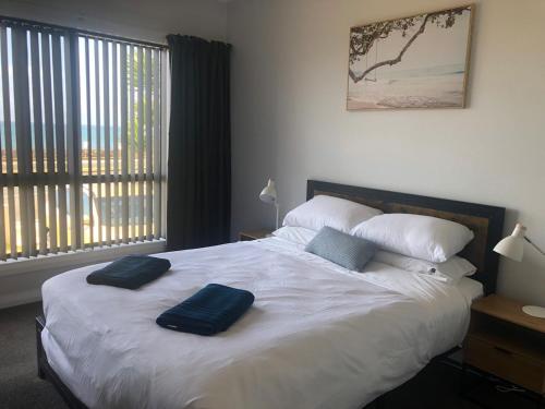 a bedroom with a bed with two blue pillows on it at Lavinia Cottage in Burnie