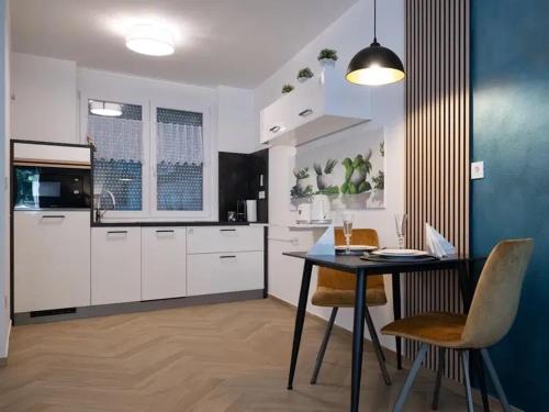 a kitchen with a table and chairs in a room at Bliss & Relax Central Apartment Debrecen, Free Parking in Debrecen