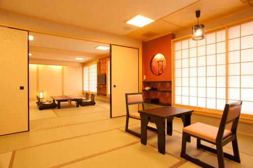 a japanese room with a table and chairs at Matsui-Bekkan Hanakanzashi in Kyoto