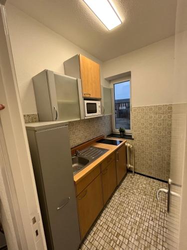 a small kitchen with a refrigerator and a sink at Ecolodge 1 Mini Apartment in Niederdorla
