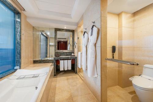 a bathroom with a tub and a toilet and a sink at DoubleTree By Hilton Wuxi in Wuxi
