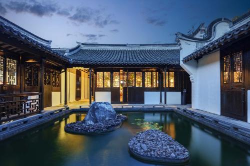 a building with a pool of water with two rocks in it at 芯宿-上海陶家宅 in Shanghai