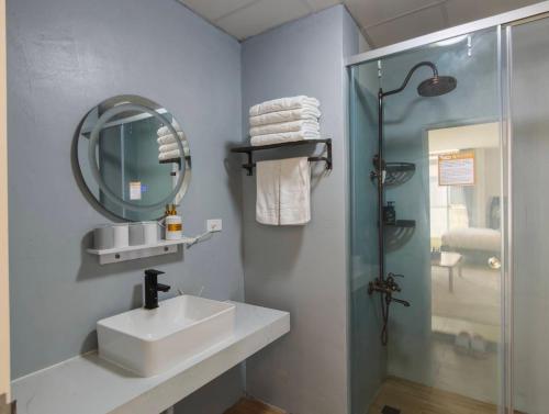 a bathroom with a sink and a shower and a mirror at 壹貳貳洋樓 l 自助入住 l 無人櫃檯 in Chiayi City