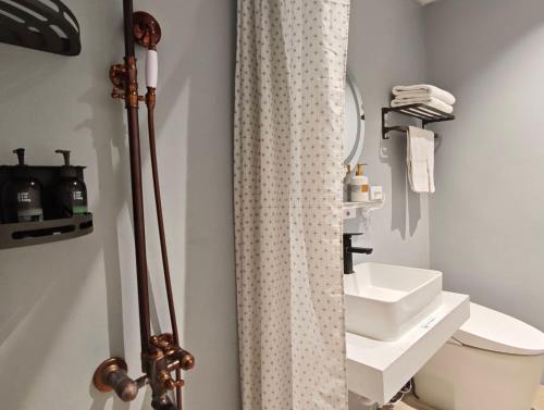 Un baño con cortina de ducha y lavabo. en 壹貳貳洋樓 l 自助入住 l 無人櫃檯, en Chiayi