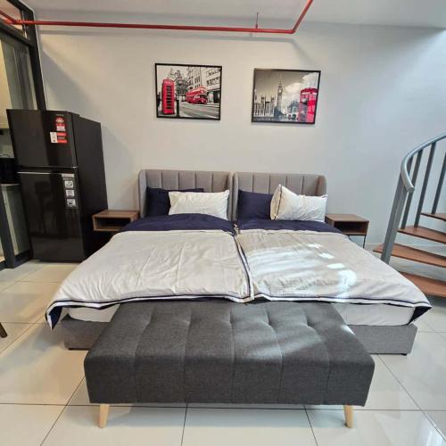 a large bed in a room with some pictures on the wall at 3 Tower Ampang Suite in Kuala Lumpur