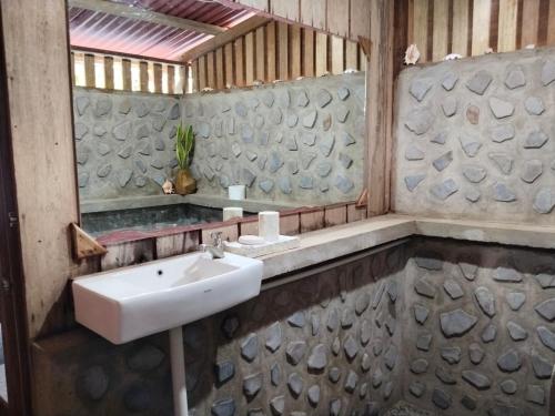 een badkamer met een wastafel en een spiegel bij Pantai Naama Bungalow 