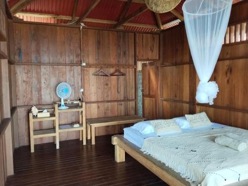 een slaapkamer met een bed en een houten wand bij Pantai Naama Bungalow 