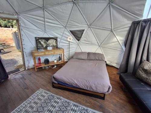 a bedroom with a bed in a tent at Secret Heated Dome, Hot Tub,Firepit Projector in Lincoln in Lincoln