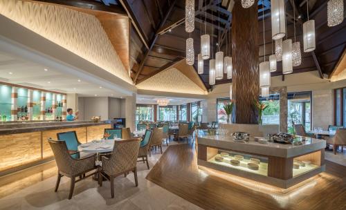 a restaurant with tables and chairs and a bar at Henann Resort Alona Beach in Panglao