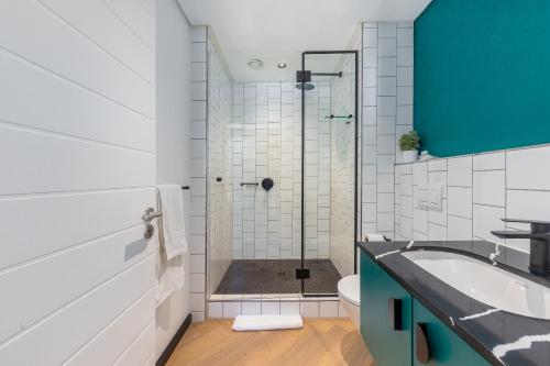 une salle de bains avec douche, lavabo et toilettes dans l'établissement Nine Palms - Century City Luxury Apartment, au Cap