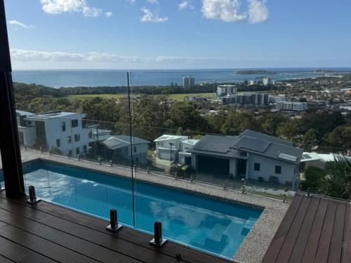 a view of a swimming pool from the balcony of a house at Mountain-Top Ocean View in Coffs Harbour in Coffs Harbour