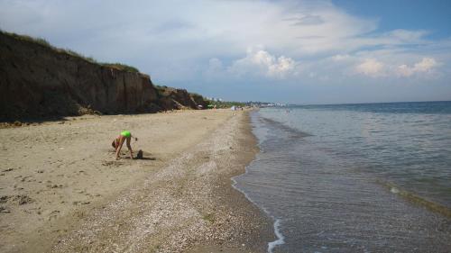 a person playing in the sand on the beach at Rosemarino Country House in Chornomorsk