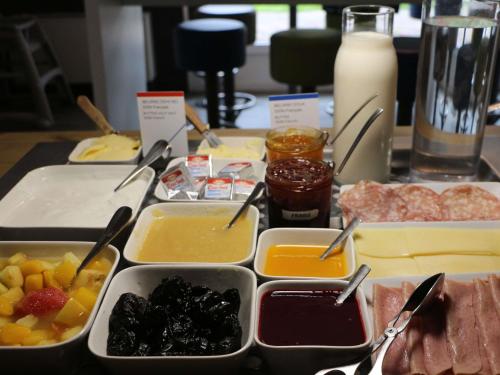 een tafel met dienbladen van verschillende soorten levensmiddelen bij Ibis Budget Agen in Le Passage