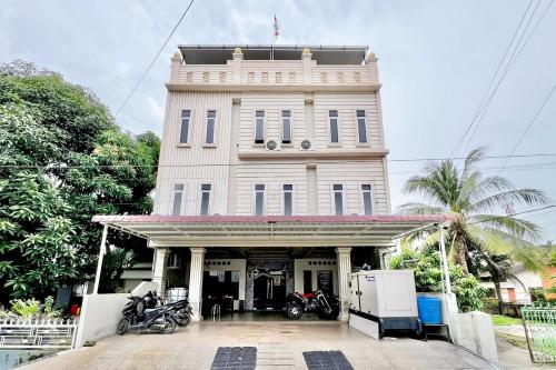 a white building with motorcycles parked in front of it at RedDoorz at Vania Residence Medan in Medan