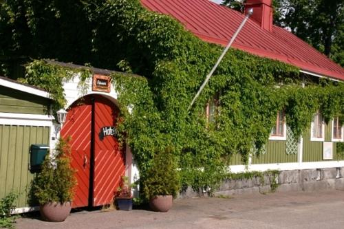 a building with a red door and ivy on it at Hotelli Luostarin Puutarha in Naantali