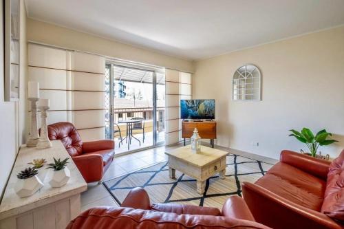 a living room with leather furniture and a tv at 16 Sleep Family Group Getaway in Gold Coast