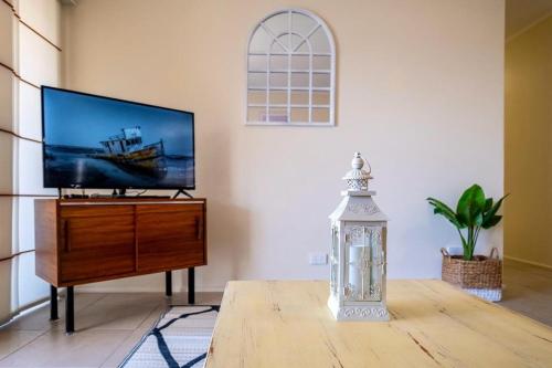 a living room with a flat screen tv on a dresser at 16 Sleep Family Group Getaway in Gold Coast
