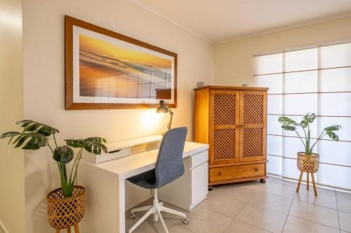 a desk with a chair and two plants in a room at 16 Sleep Family Group Getaway in Gold Coast