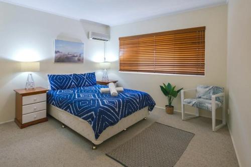 a bedroom with a bed and a chair and a window at 16 Sleep Family Group Getaway in Gold Coast