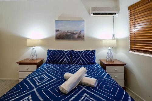 a bedroom with a blue bed with two night stands at 16 Sleep Family Group Getaway in Gold Coast