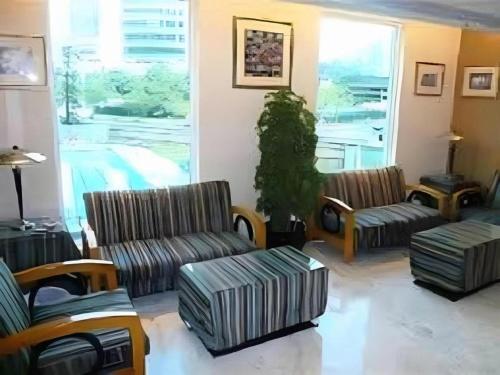 un salon avec deux canapés et une grande fenêtre dans l'établissement Largos Hotel, à Hong Kong