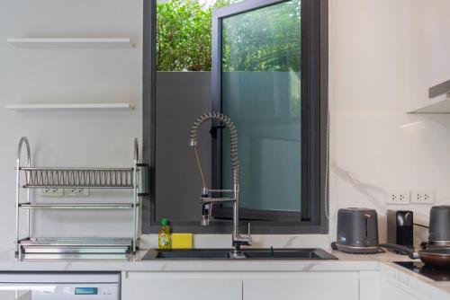 une cuisine avec un évier et une fenêtre dans l'établissement Nicky Luxury Private Pool Villa in BangTao Laguna, à Laguna Phuket