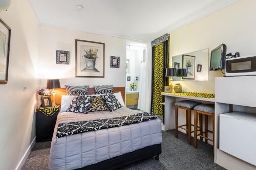 - une petite chambre avec un lit et un bureau dans l'établissement Airport Riverview Motel, à Brisbane