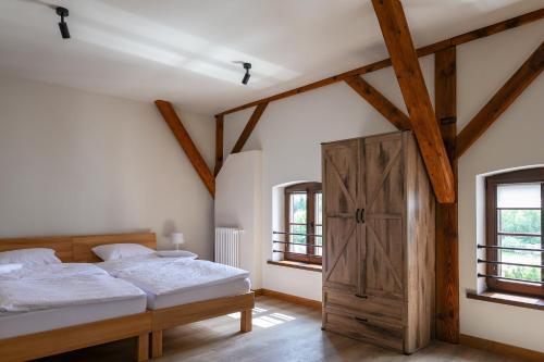 a bedroom with two beds and a wooden door at Młyn Melzak in Pieniężno