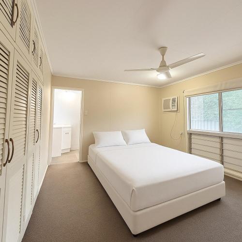 a bedroom with a white bed and a window at 31 Leichhardt Dr Relaxing 3Bed Home in Moranbah