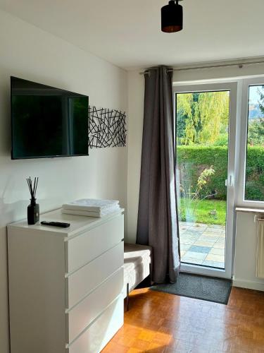 a room with a dresser and a sliding glass door at Schwabenperle Apartments in Lauchheim