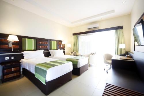 Best Western Premier Garden Hotel Entebbe tesisinde bir odada yatak veya yataklar