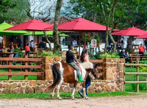 a man and a woman riding a horse at Magnífica Cabaña en Pony Parque Mesa de los Santos in Piedecuesta